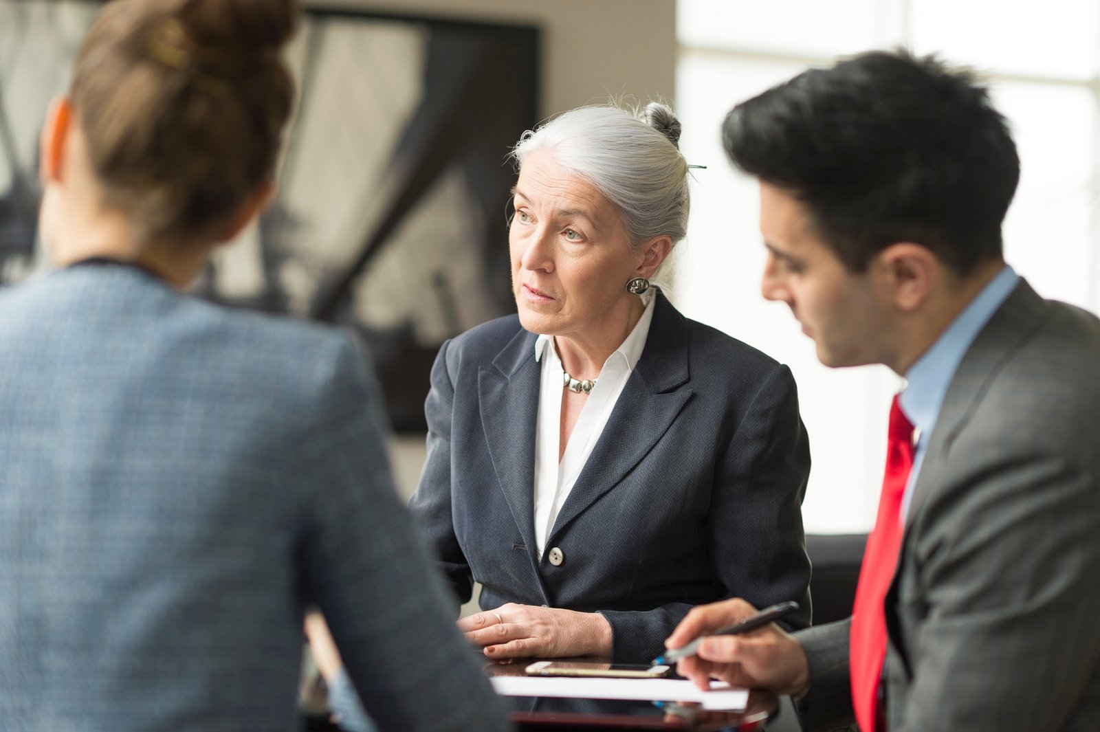 Businessman discussing with female colleagues in boardroom meeting